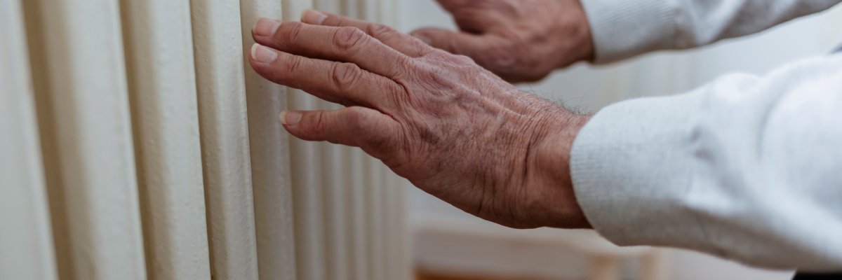 Man warms up hands over heater.